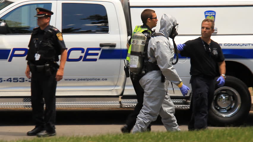MISSISSAUGA, CANADA - JULY 1 2012: Police in hazardous materials suits working outside an apartment building in Mississauga, Ontario, Canada where a "suspicious death" has occurred.