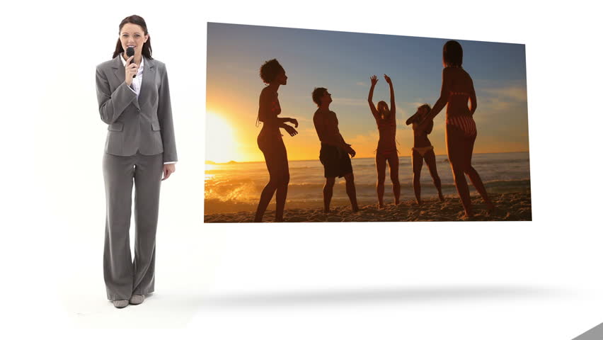 Woman in suit reporting on fun at the beach with microphone
