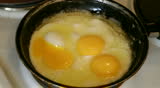 Fried eggs from three eggs. Seasoning is strewed before preparation