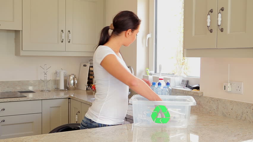 Woman putting plastic bottles into recycling bin