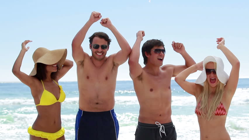 Four friends partying together on the beach while on holidays