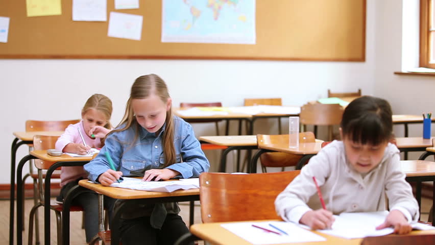 Serious pupils writing in the classroom