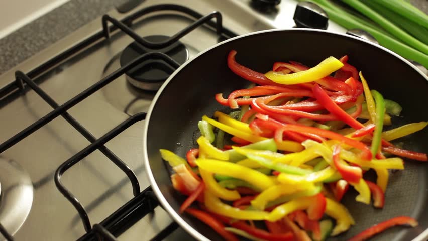 Slices of paprika frying on pan for fajita