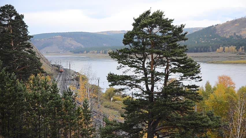 Cargo train is moving on river bank