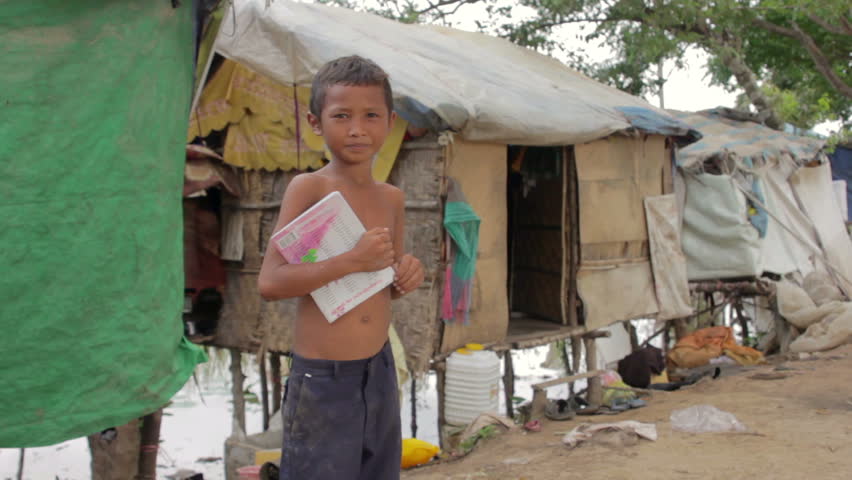Boy in slum holding book want to go school