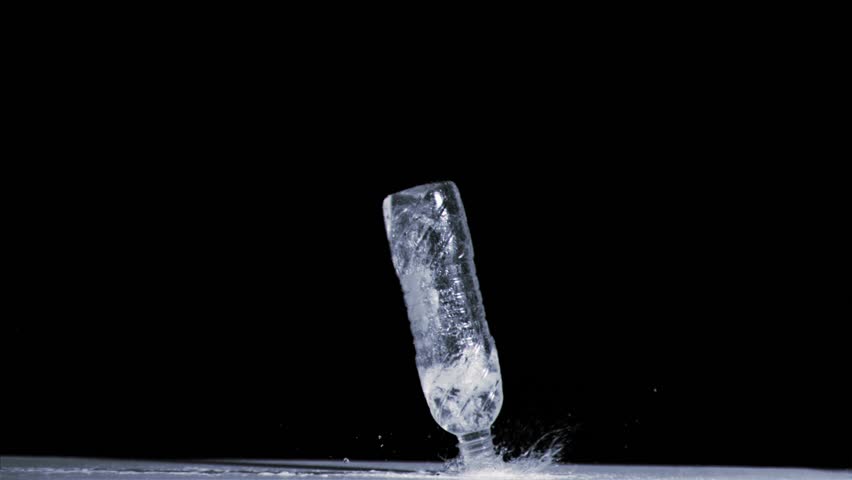 Water spilling out in super slow motion from a bottle against black background