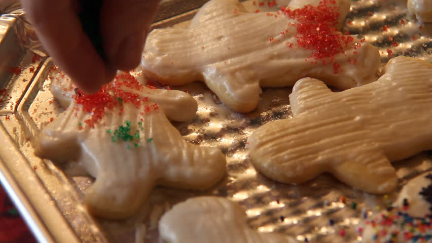 Baking Sugar Cookies 21. Preparing, mixing, baking and decorating Christmas sugar cookies. Decorating the iced cookies with seasonal sprinkles.