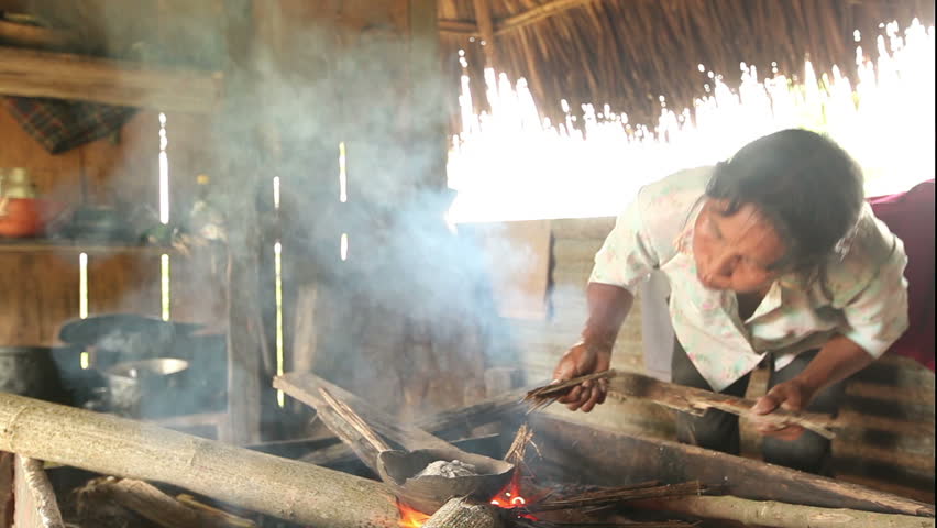 Adult woman making pottery , rural scene in ecuadorian Amazonia. Temperature is gently controlled by hand in order to prevent cracking while the craftman blows air with her mouth