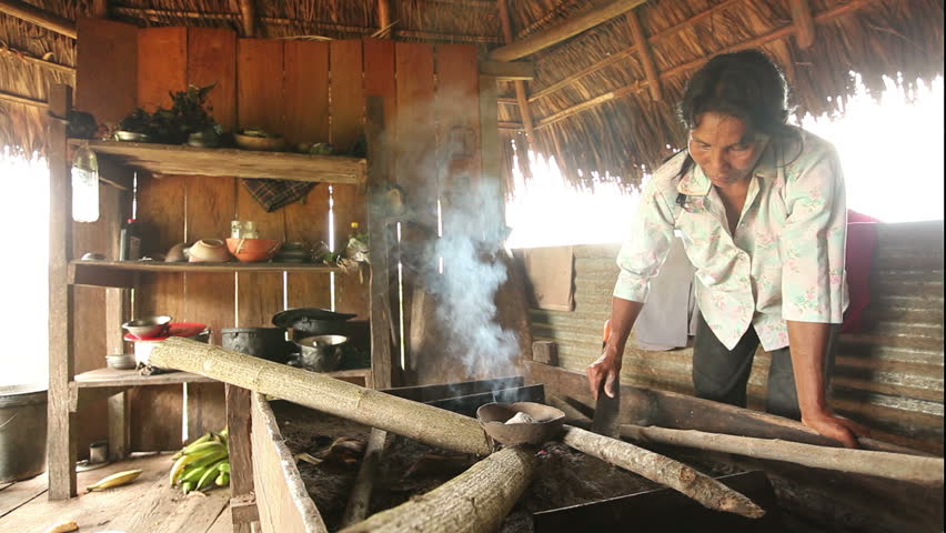 Adult woman making pottery, rural scene in ecuadorian Amazonia, When the desired temperature is reached the pot is covered with ash to prevent craking an to maintain a constant temperature.