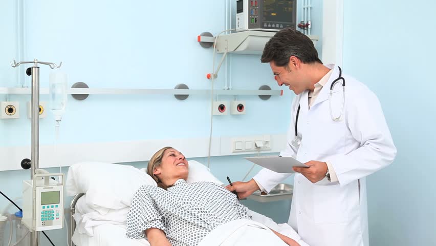 Doctor speaking to his patient in hospital ward