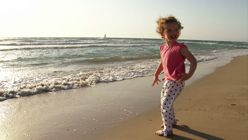 Girl playing with waves at the beach