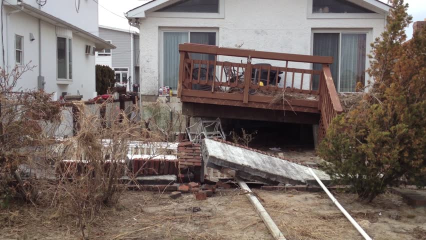 BREEZY POINT, QUEENS, NY-December 2, 2012: Footage clip of damaged home from waves and storm surge due to Hurricane Sandy. Video tilts up to reveal debris on deck that was uplifted from ocean water.