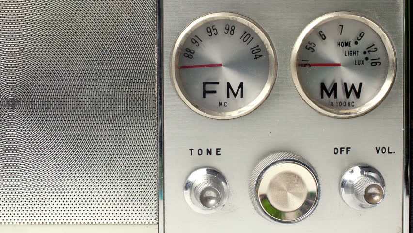 an old vintage portable FM and MW transistor radio with  the marker running through the different stations and frequencies