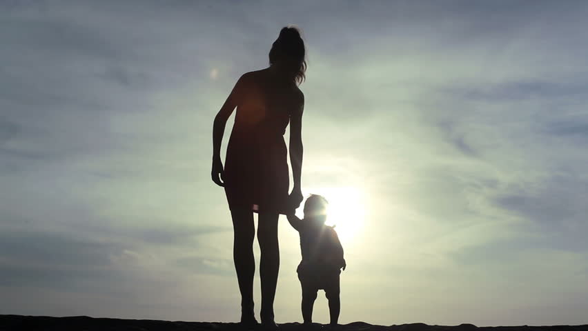 young mother keeping her baby child by the hand and going forward