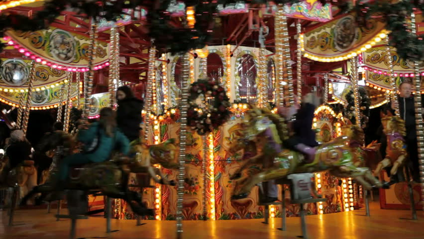 EDINBURGH, SCOTLAND - DECEMBER 16: Revelers riding a carousel at the Christmas Fair in Princes Street Gardens on Dec 16, 2012, an attraction enjoyed by thousands of visitors to Edinburgh each year.