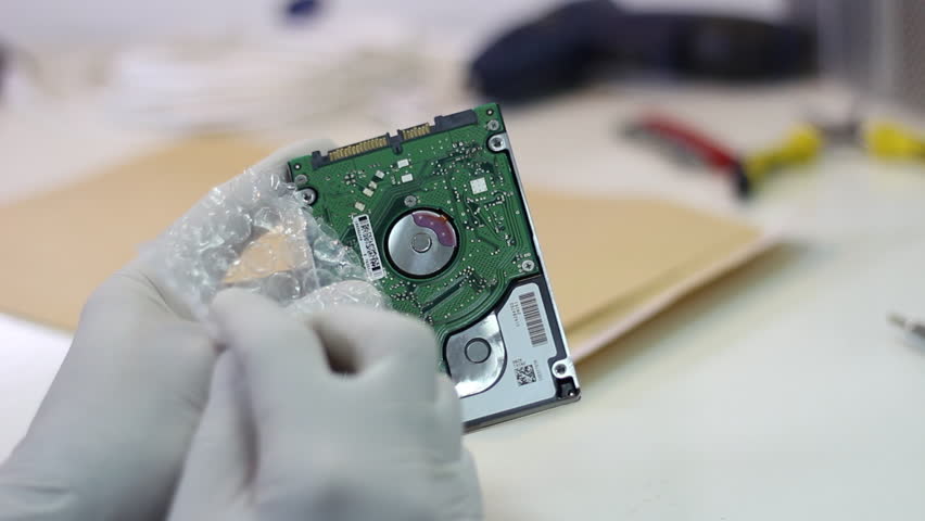 Technician wrapping hard drives for shipment    