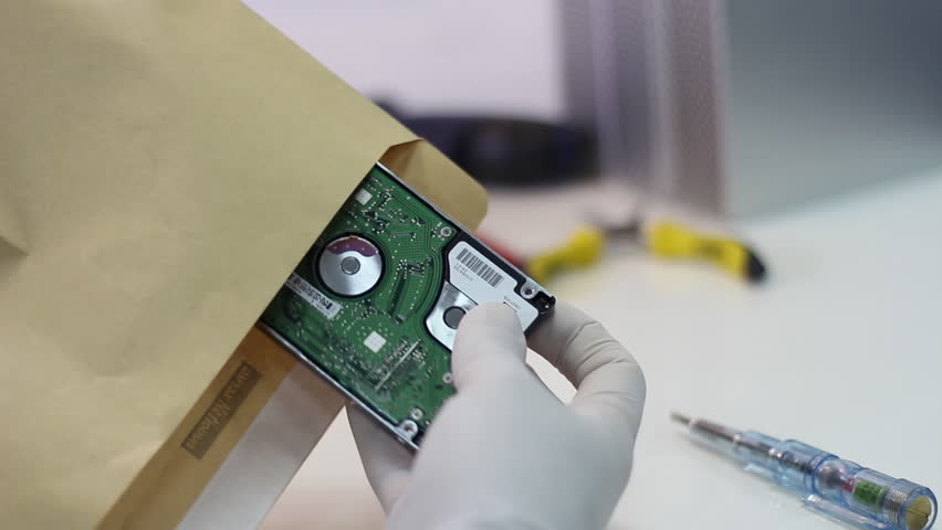 Technician wrapping hard drives for shipment    