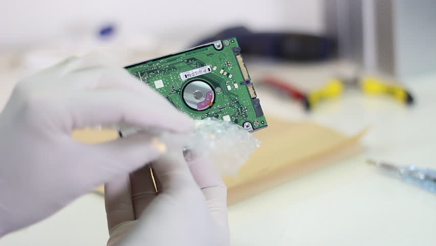 Technician wrapping hard drives for shipment    