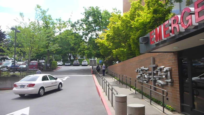 PORTLAND, OREGON - CIRCA 2012: Pan shot of hospital entrance at emergency room with people exiting front door.