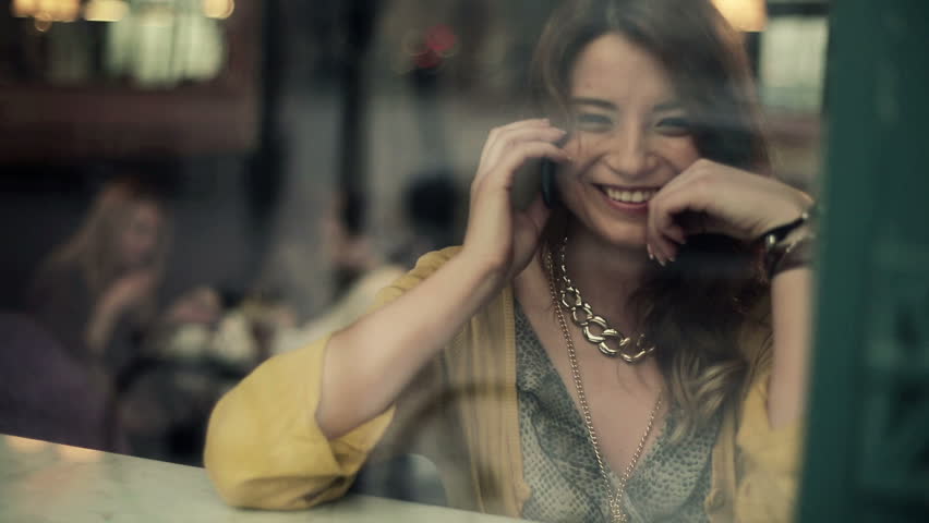 Beautiful woman talking on cellphone in cafe, steadicam shot