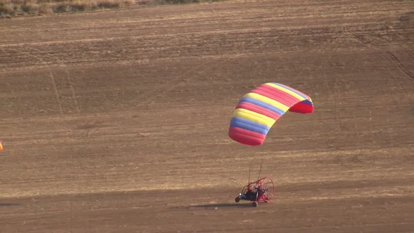 VALLEY OF JEZREEL, ISRAEL - OCTOBER 04: Motorized parachute takes off  while avoiding collision during competition of ultralight airplanes, near mount Gilboa, Israel on October 04 2012.