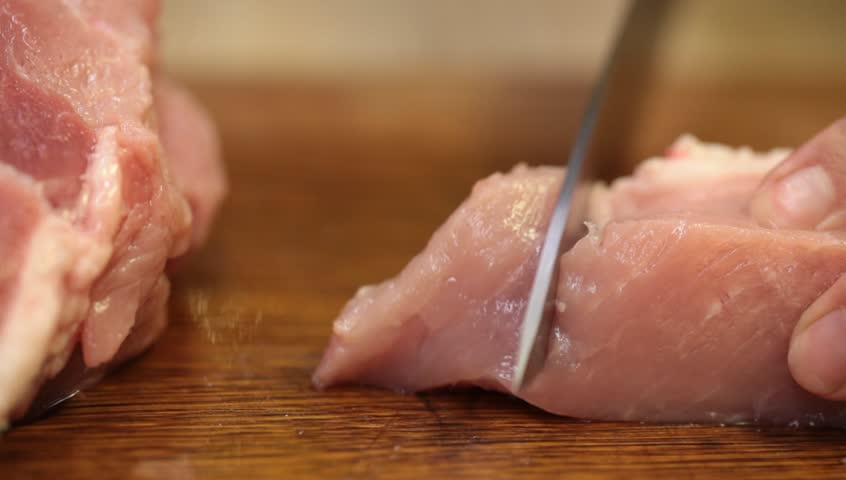 Cutting meat on a wooden kitchen board