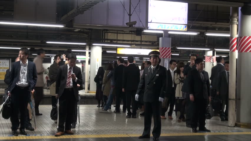 TOKYO, JAPAN - 6 NOVEMBER 2012: Commuter train leaves from platform of Shinagawa station, conductor visible in the background, in Tokyo