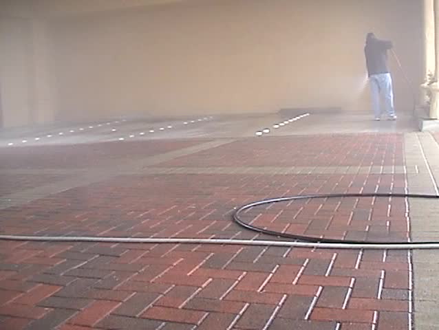 an unidentifiable person shows how to expertly power wash or Steam Clean a parking lot