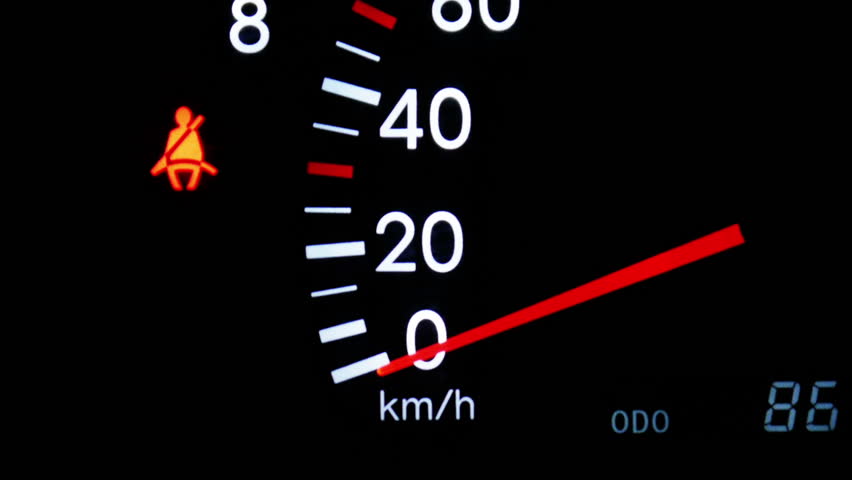 Close-up of a accelerating tachometer with an icon of seat belt