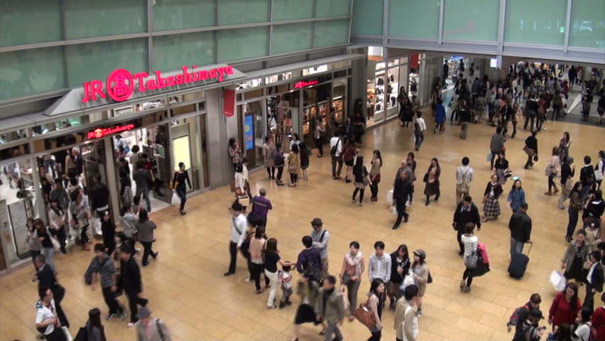 NAGOYA, JAPAN - 20 OCTOBER 2012: Commuters walking through the busy Nagoya train station during rush hour (handheld video from escalators, includes zoom towards main transit hall)