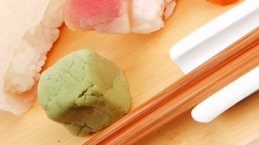 Japanese traditional cuisine - Set of Tuna (maguro) Salmon (sake) and Eel (unagi) Nigiri Sushi with Wasabi and chopstick on wooden plate hidef slow motion