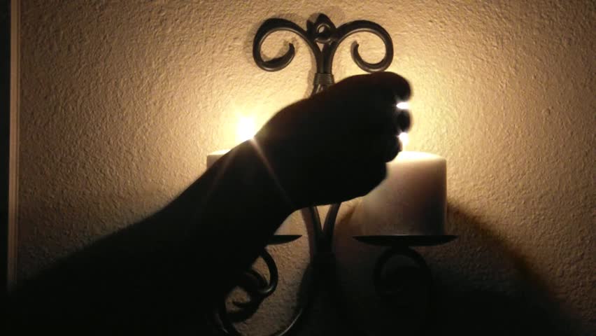 Lighting brown candles in the dark with matches and then they burn shortly.
