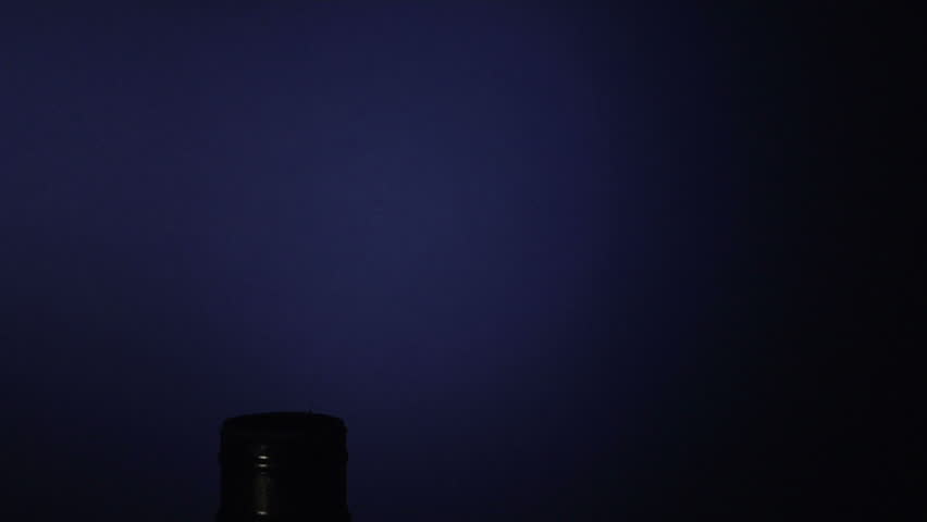 hand screws in a cfl lightbulb on a blue background