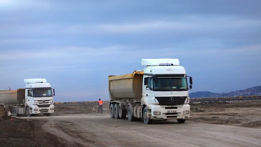 ISTANBUL - DEC 30: Heavy duty dump trucks work for formation of new land by filling the sea at Maltepe Coast on December 30, 2012 in Istanbul. Transfer camions running to haul such as gravel or rock.