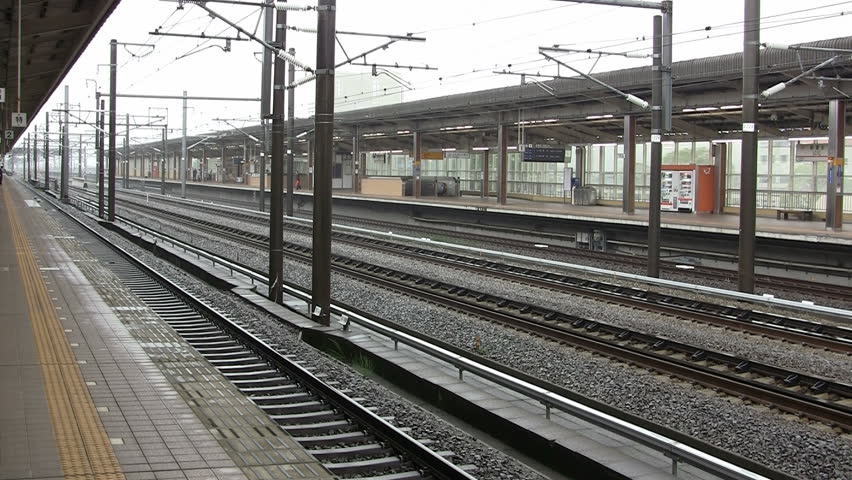 Two Shinkansen bullet train passeing  a station at high speed (Japan)