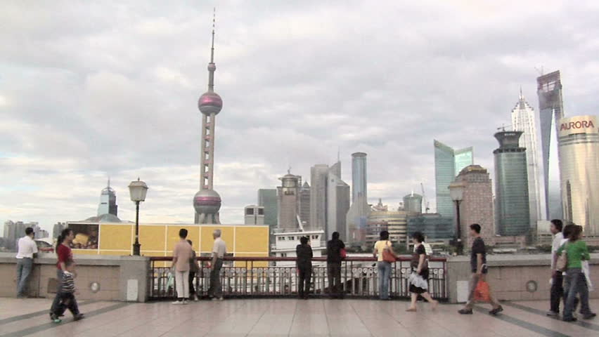 SHANGHAI, CHINA - CIRCA OCTOBER 2007: Skyline of Pudong with the Oriental Pearl TV Tower and the Huangpu River with a Boat carrying an Advertising Panel, passing by