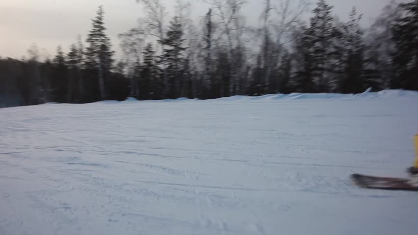 STEADYCAM: Snowboarder riding down the hill. Follow shot. 