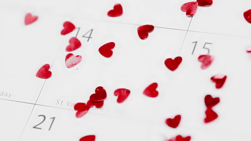 Pink heart confetti falling on calendar showing Valentines day