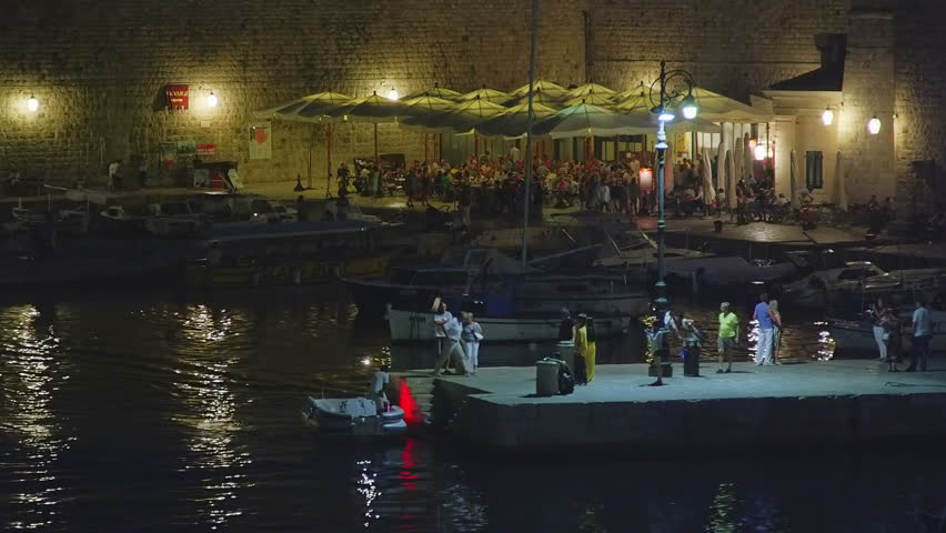 DUBROVNIK, CROATIA - SEPTEMBER 3 2012 - Summer atmosphere with tourists sightseeing and movement around restaurants in the old town harbor on September 3, 2012. in Dubrovnik, Croatia.