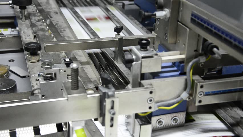 folding machine folds printed offset sheet as part of newspaper brochure in print house