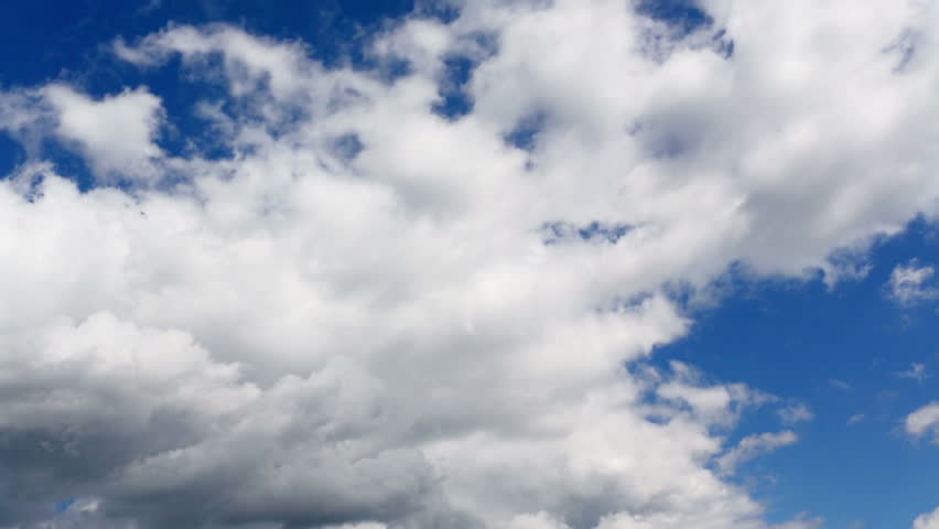 Time lapse clip of white fluffy clouds over blue sky