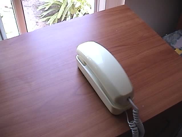 a person picks up the receiverand dials a fictitious phone number on an old push button  telephone with sound