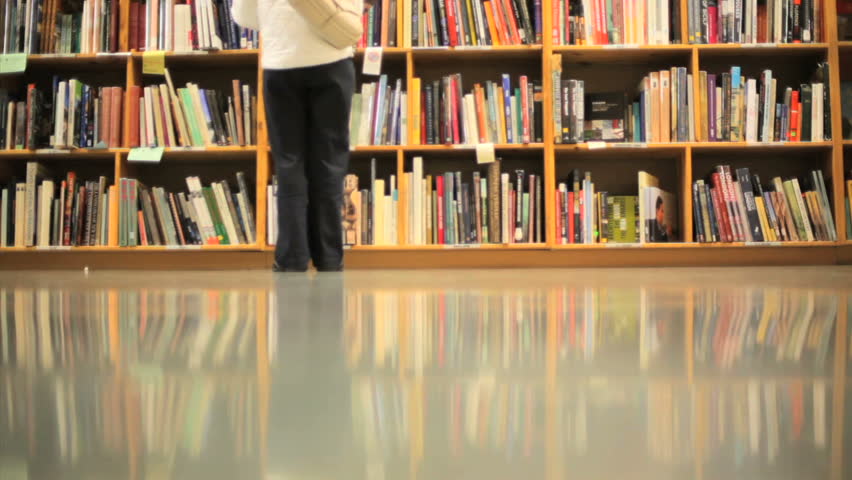 People walking in front of stacks of books