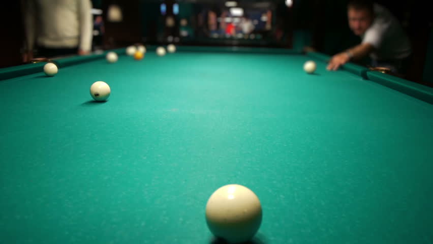Playing pool, hitting the ball closeup view