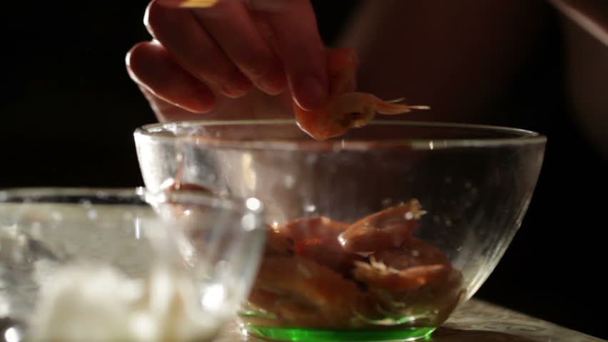 Women's hands are cleaning shrimp. Closeup shot backlit.