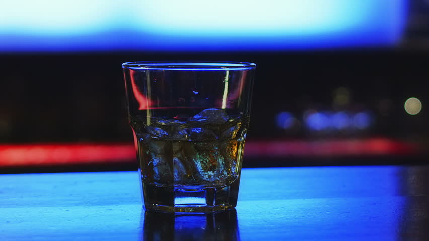 Drinking in the bar, dark depressed atmosphere and glass for a lonely drinker.