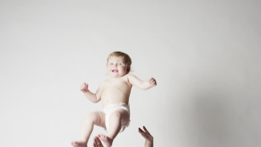 Father playfully throws his baby daughter in the air, and catches her. Slow motion (300 fps)