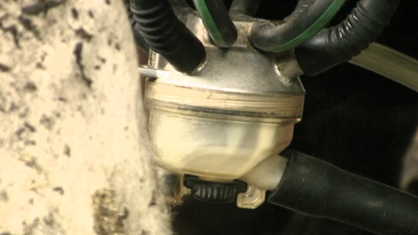 Closeup of a milking machine extracting milk from a cow's udder