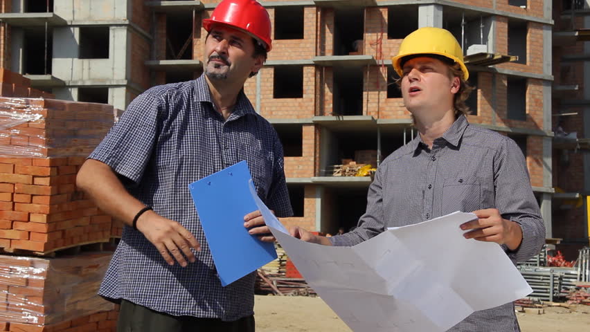 Construction workers, planning and controlling building of apartments, teamwork