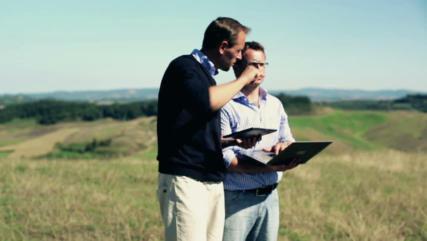 Real-estate agent with tablet computer showing property to investors, crane shot
